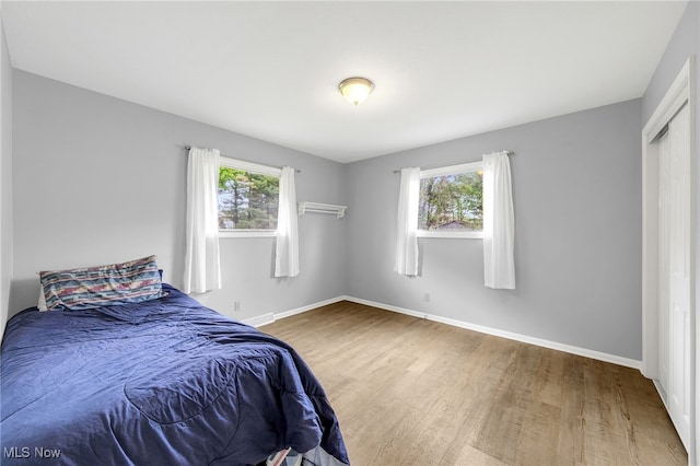 bedroom with baseboards and wood finished floors