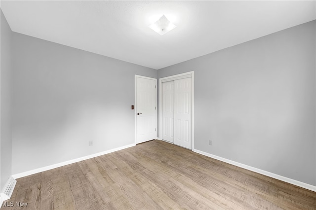 spare room featuring baseboards and wood finished floors
