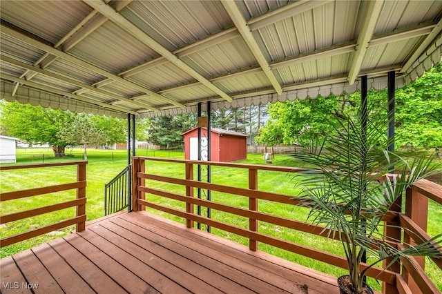 wooden terrace with a yard, fence, an outdoor structure, and a storage unit