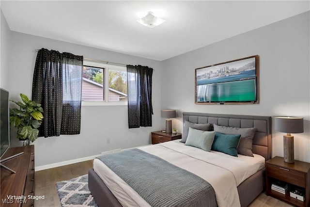 bedroom featuring baseboards and wood finished floors
