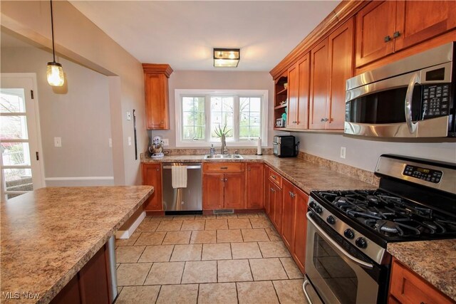 kitchen with a sink, appliances with stainless steel finishes, light tile patterned floors, and brown cabinets