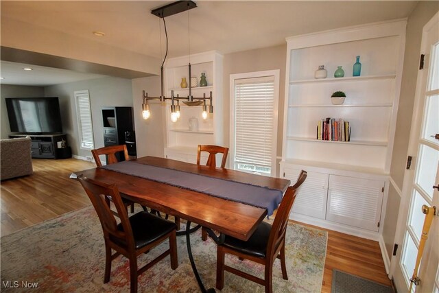 dining area with built in shelves, baseboards, recessed lighting, and wood finished floors