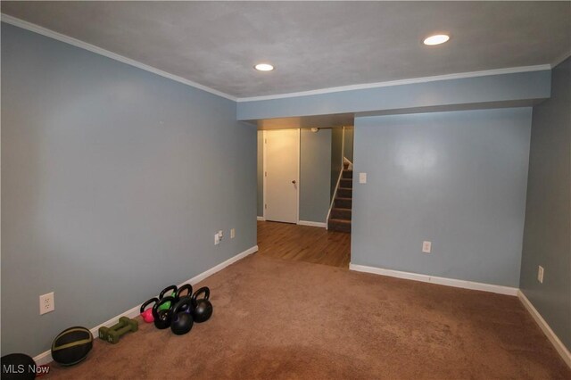 carpeted empty room with baseboards, ornamental molding, and stairs