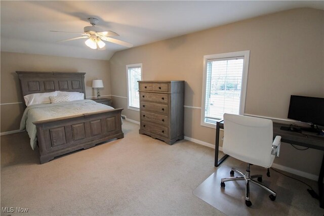 bedroom featuring baseboards, light carpet, vaulted ceiling, and multiple windows
