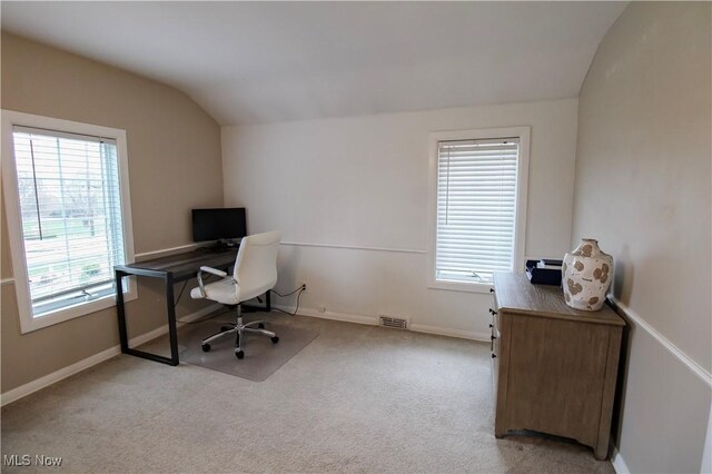 carpeted home office featuring baseboards, lofted ceiling, and a wealth of natural light