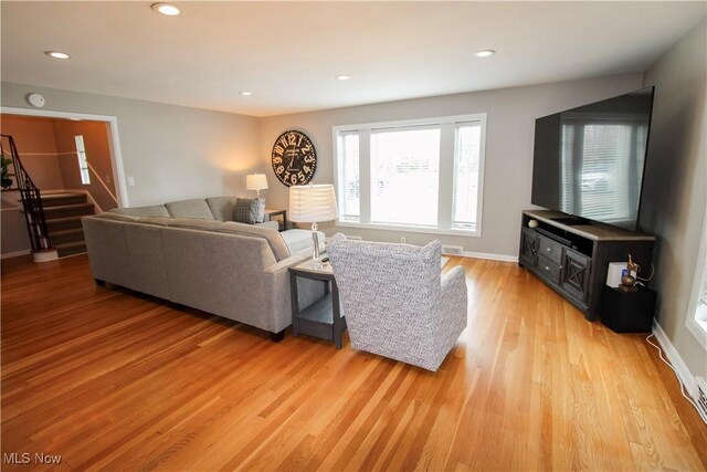 living room featuring stairway, baseboards, recessed lighting, and light wood-style flooring