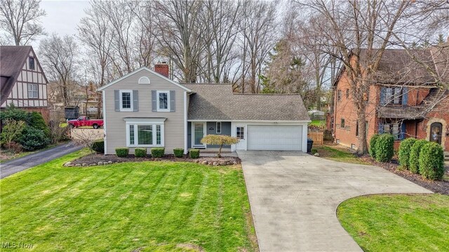 traditional home with an attached garage, driveway, a chimney, and a front yard