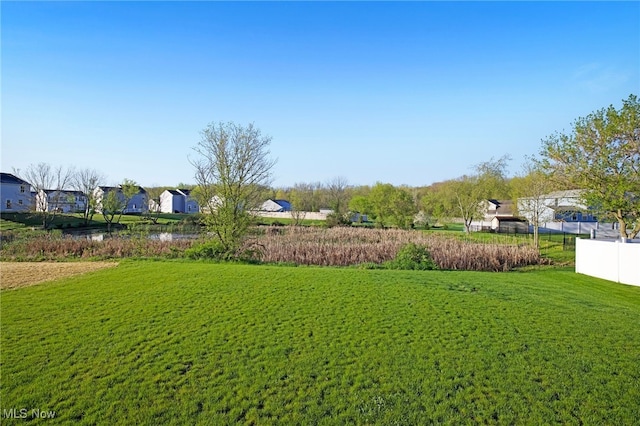 view of yard featuring fence and a residential view