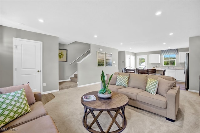 living room with recessed lighting, stairway, and light colored carpet