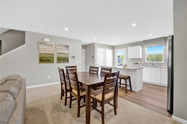 dining room featuring recessed lighting, baseboards, and light colored carpet