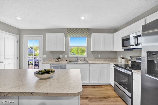 kitchen with a sink, appliances with stainless steel finishes, white cabinets, and recessed lighting