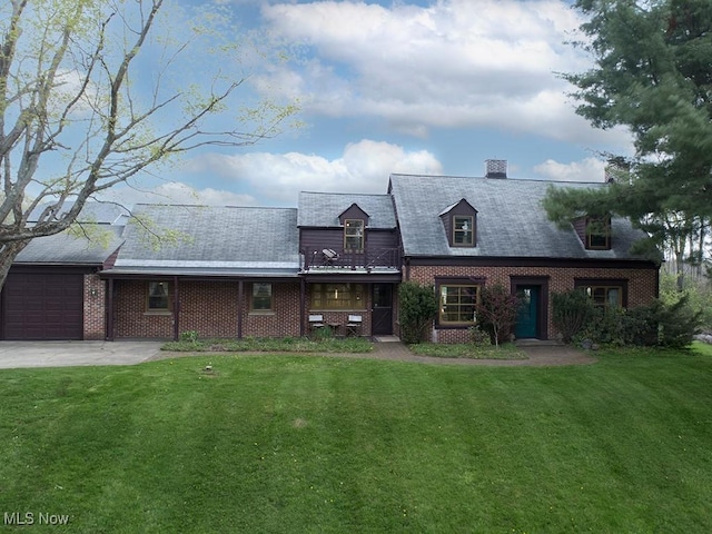 exterior space with a chimney, brick siding, a balcony, a yard, and an attached garage