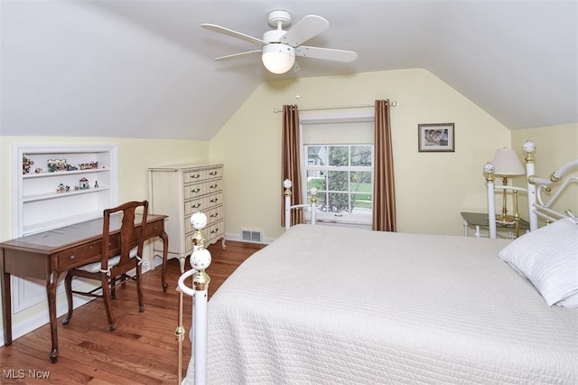 bedroom featuring ceiling fan, lofted ceiling, wood finished floors, and visible vents