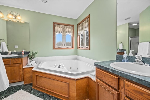 bathroom with a whirlpool tub, a sink, two vanities, and a shower stall