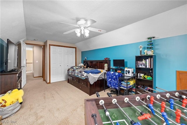carpeted bedroom with a closet, ceiling fan, and vaulted ceiling