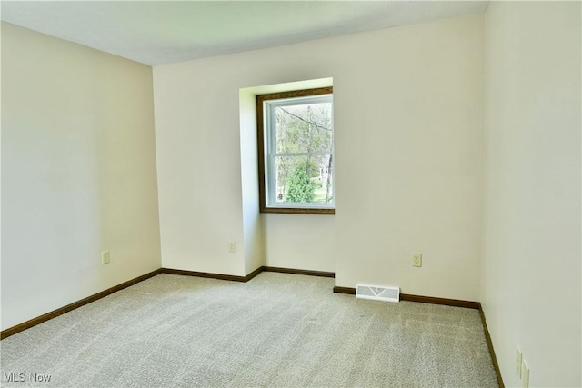 carpeted spare room with baseboards and visible vents