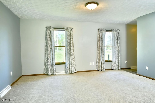 unfurnished room with carpet floors, a textured ceiling, and a healthy amount of sunlight