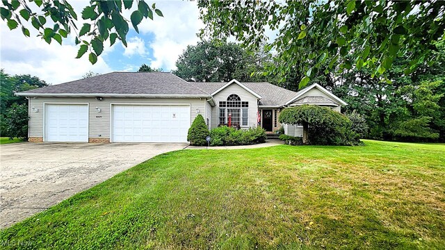 ranch-style home with a garage, driveway, and a front lawn