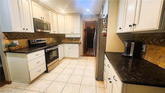 kitchen featuring backsplash, stainless steel appliances, light tile patterned flooring, and white cabinetry