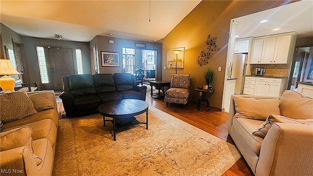living room featuring recessed lighting, lofted ceiling, and wood finished floors