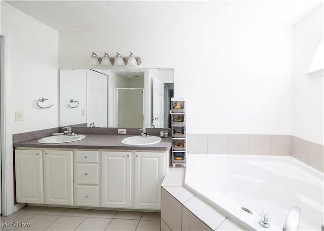 full bathroom with tile patterned flooring, a sink, a bath, and a shower stall