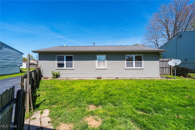 back of property with a lawn and a fenced backyard