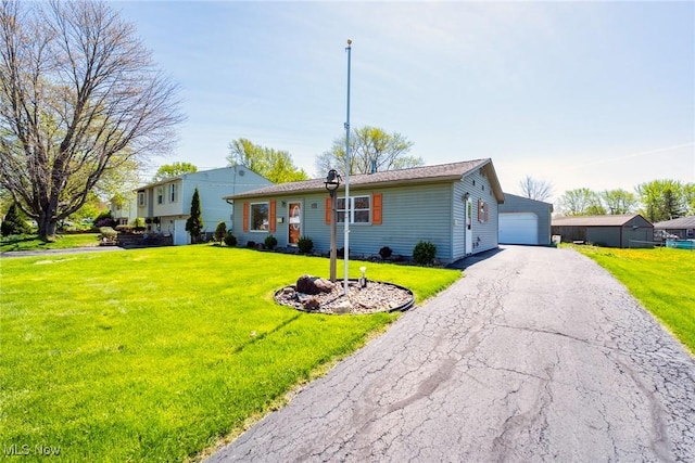 split level home with a detached garage and a front yard