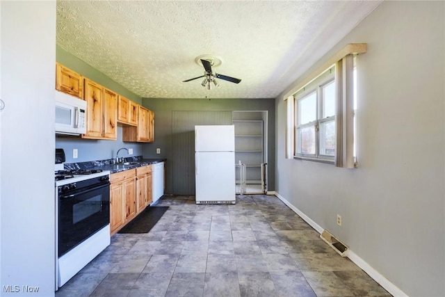 kitchen with ceiling fan, a textured ceiling, visible vents, baseboards, and white appliances