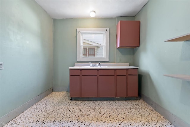 laundry room with baseboards and a sink