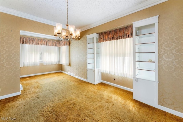 carpeted spare room featuring a textured ceiling, an inviting chandelier, ornamental molding, and baseboards