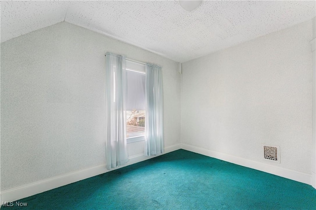 carpeted spare room with visible vents, baseboards, and vaulted ceiling