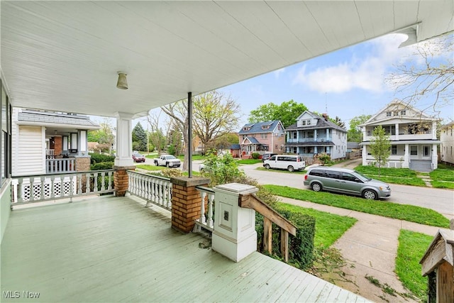 deck with a residential view and covered porch