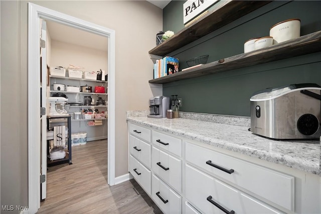 interior space featuring baseboards, a toaster, and light wood-style floors
