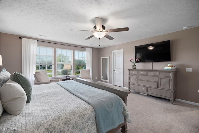 bedroom with visible vents, carpet flooring, baseboards, a textured ceiling, and a ceiling fan
