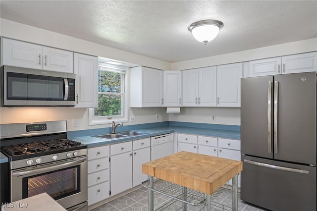 6414 Glenallen Ave, Solon, OH 44139 - kitchen with stainless steel appliances, a sink, white cabinetry, a textured ceiling, and light tile patterned flooring