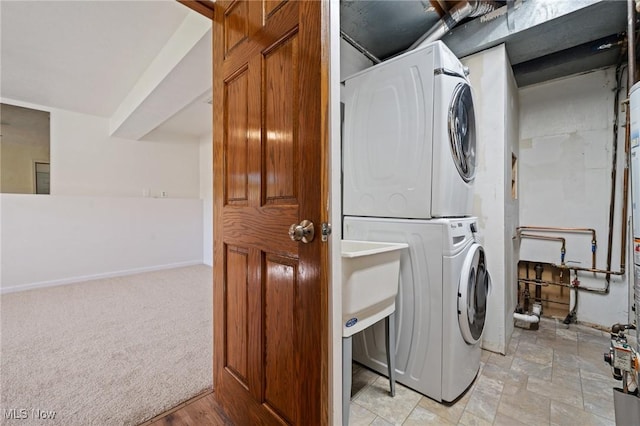 laundry room with laundry area, stacked washer and dryer, and baseboards
