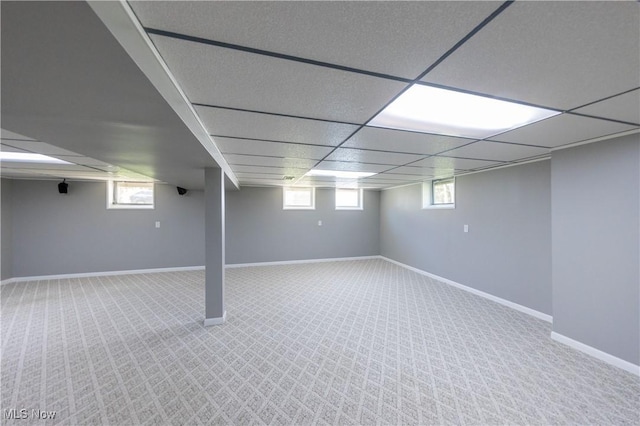 below grade area featuring carpet floors, a paneled ceiling, and baseboards