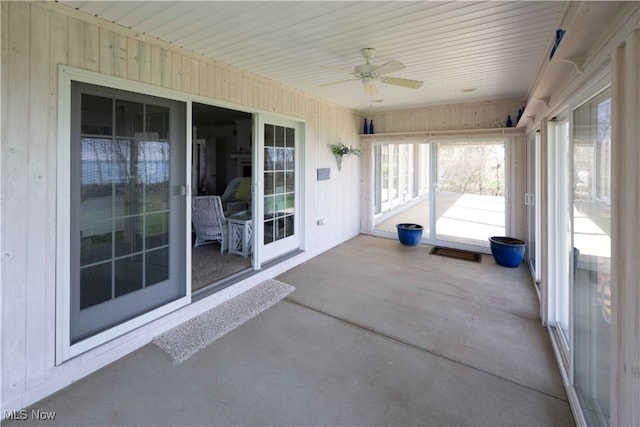 unfurnished sunroom with ceiling fan