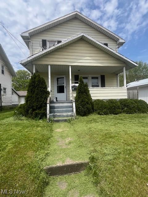 view of front facade with covered porch and a front yard
