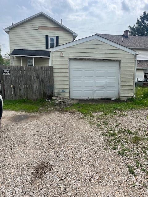 garage with fence and driveway