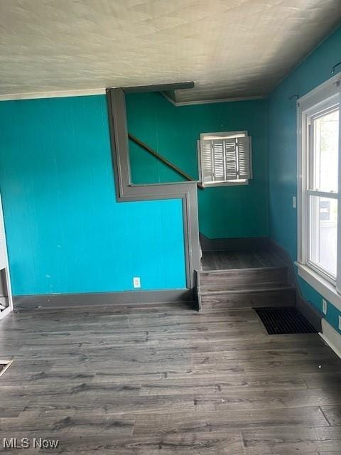 spare room with visible vents, baseboards, and wood finished floors