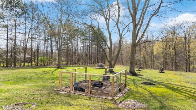 view of yard with a garden and a forest view