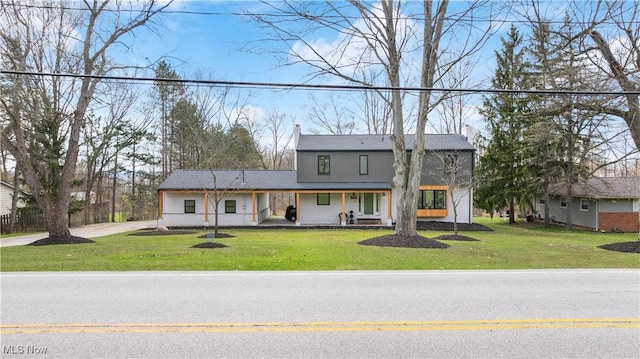 view of front of property featuring a porch, a front lawn, and a chimney