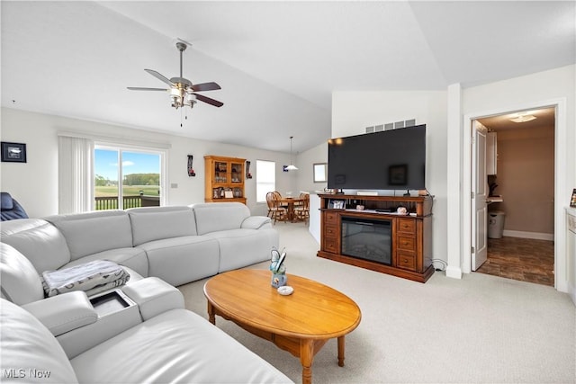 living area featuring carpet flooring, ceiling fan, a healthy amount of sunlight, and lofted ceiling