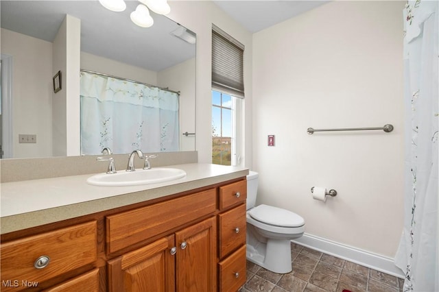 full bathroom featuring toilet, baseboards, and vanity