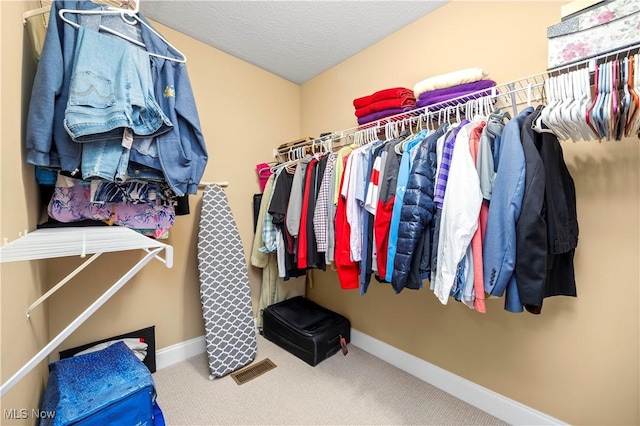 walk in closet featuring visible vents and carpet