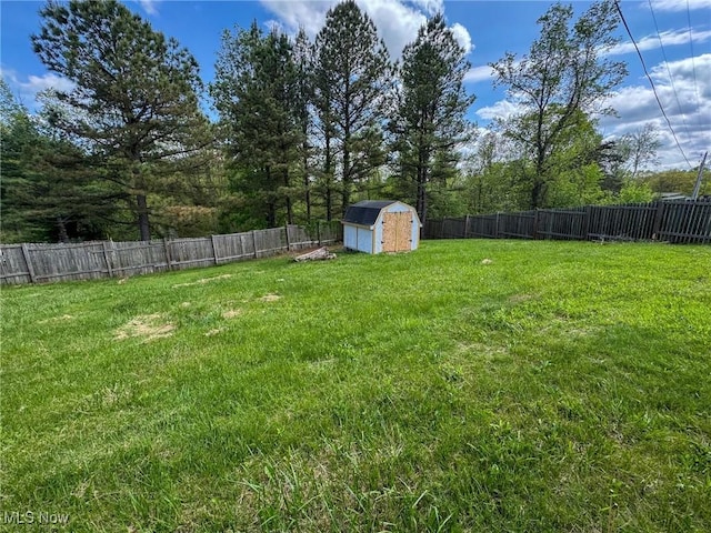 view of yard with an outbuilding, a shed, and a fenced backyard