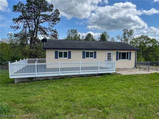 rear view of property with a patio, a yard, and a deck