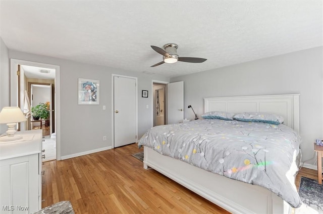 bedroom featuring light wood-style floors, a ceiling fan, and baseboards