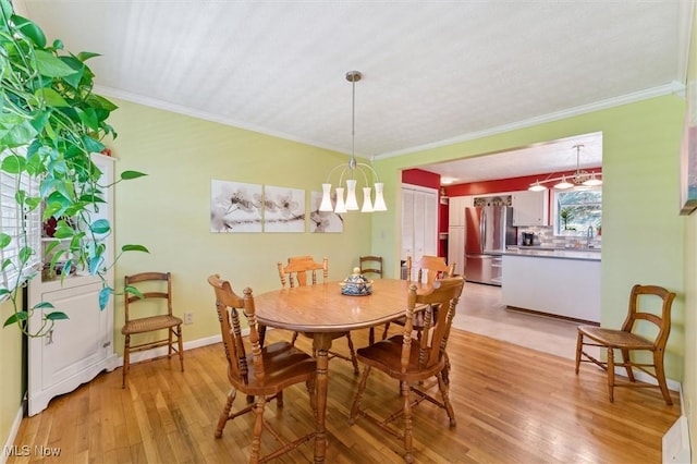 dining space featuring an inviting chandelier, light wood-style floors, and crown molding